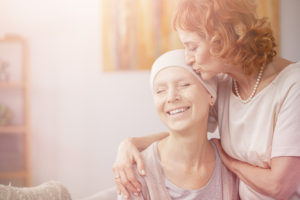 woman with cancer receiving care from an older woman