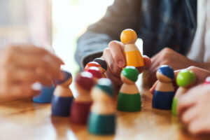 Human Resources - People choosing and picking up wooden figure from a group on the table