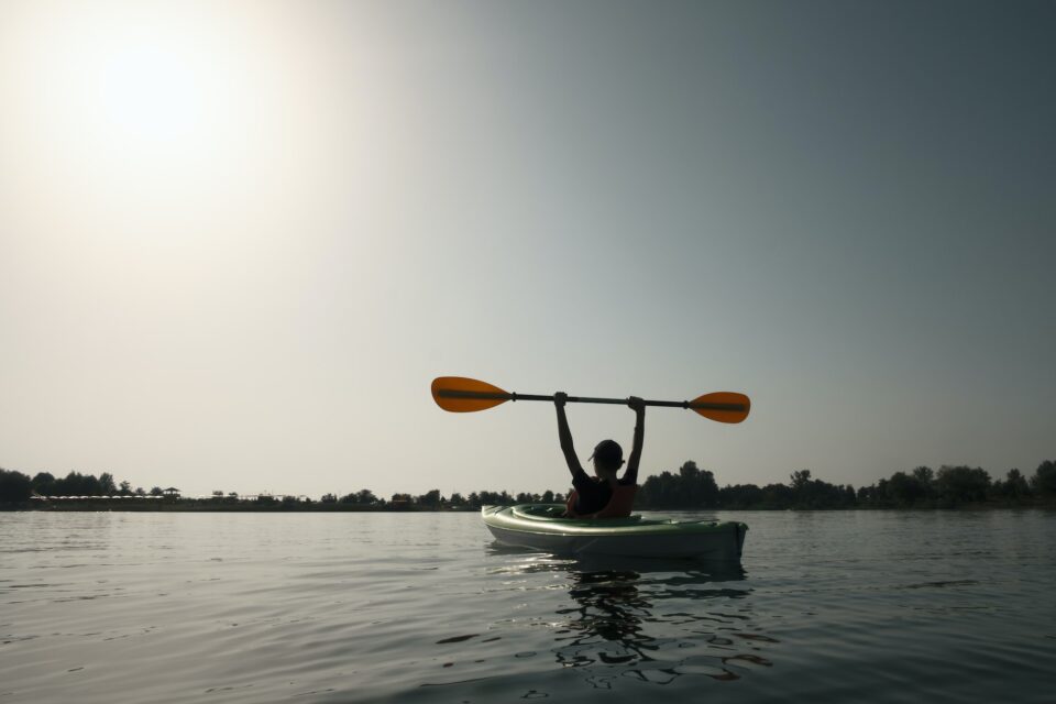 person in life jacket on green kayak; Wheelhouse cancer benefits for employers will help cancer patients navigate through cancer journey