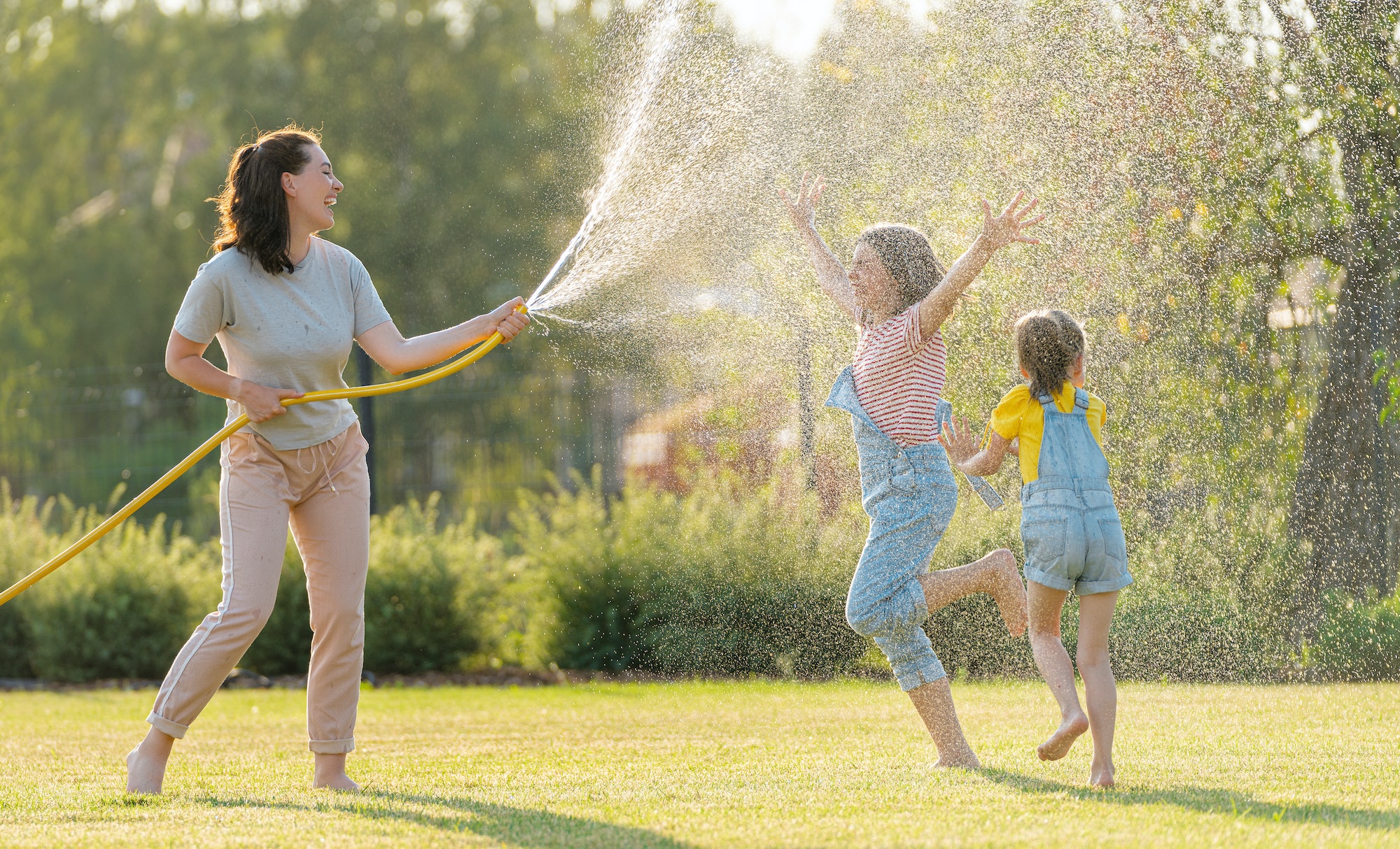 Happy family playing in backyard, using sun protection